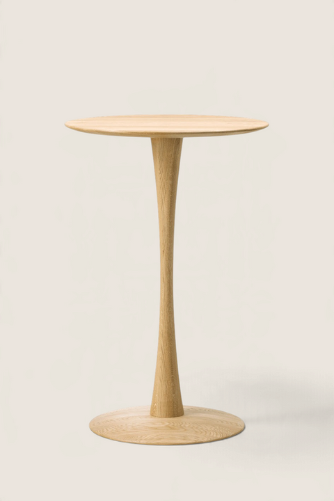 Bolina Trisse bar table in soap-treated oak with a sculptural, turned pedestal base and round top.