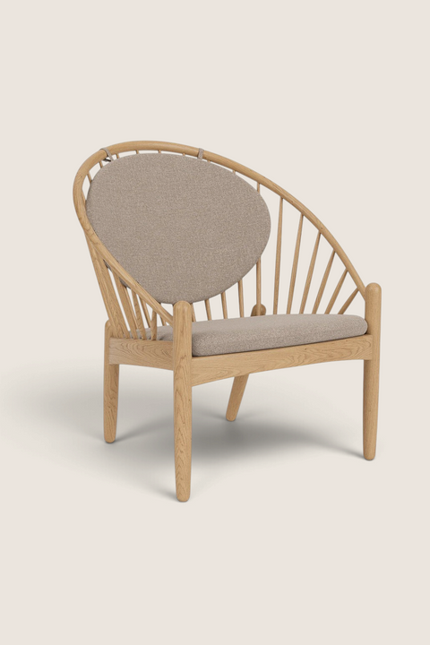 Bolina J166 Jørna lounge chair in lacquered oak with beige fabric cushions and a curved spindle back design.