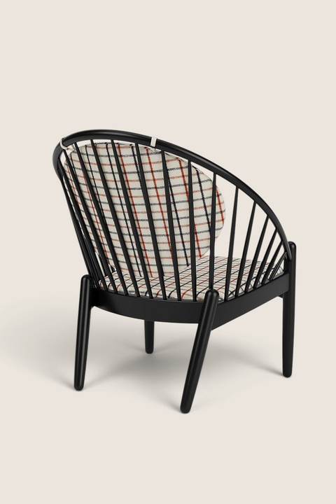 Bolina J166 Jørna lounge chair in black oak with red plaid textile cushions, featuring a curved spindle back design.