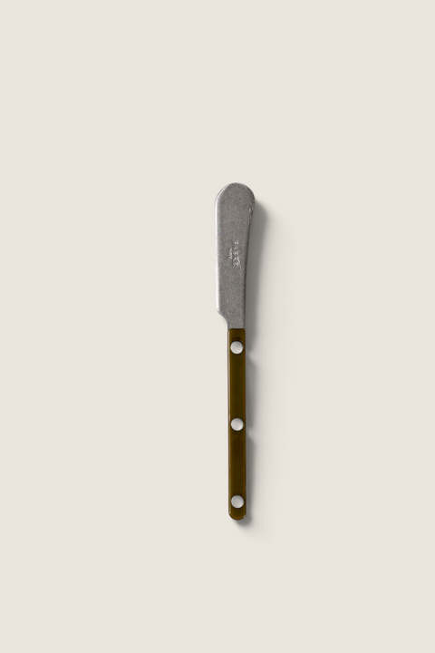 Bolina smørkniv fra Sabre Paris i serien Bistrot Vintage med grønt skaft og synlige nagler på en lys tekstilbakgrunn.