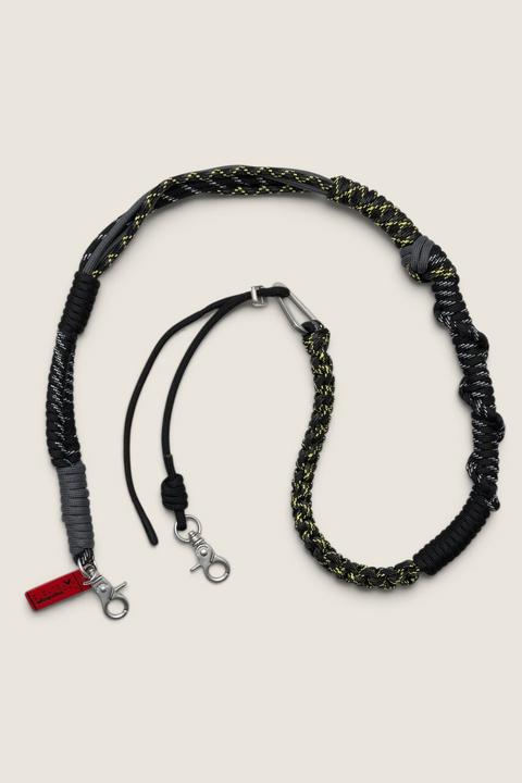 Bolina Macrame Strap i sort og gul poly-tau med dekorative knuter og justerbar lengde for vesker og mobildeksler.