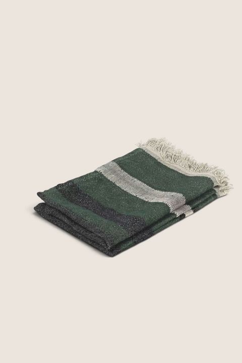 Bolina The Belgian Towel in racing green linen with striped pattern and fringed edges, folded on a white background.