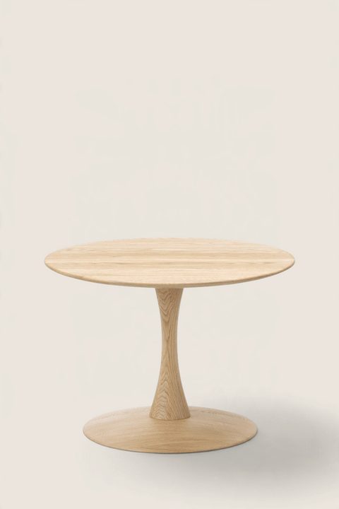 Bolina Trisse coffee table in soap-treated oak with a round top and sculptural pedestal base on a light background.
