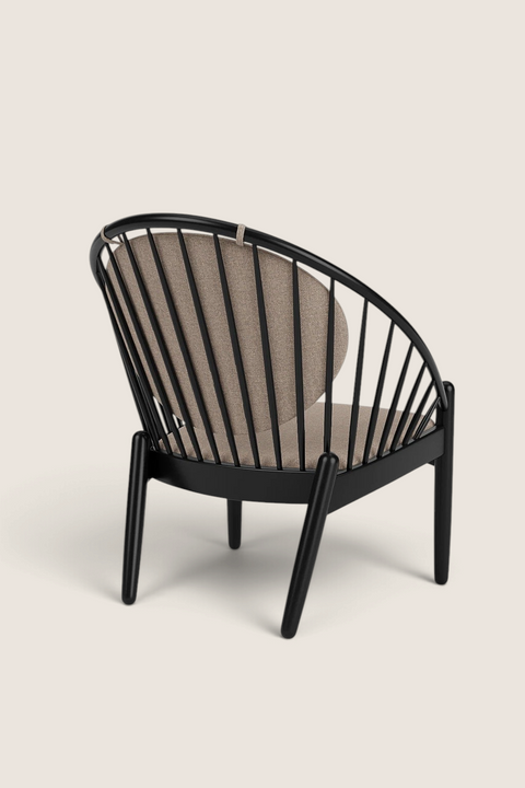 Bolina J166 Jørna lounge chair in black painted oak with beige cushions, featuring a curved spindle back design.