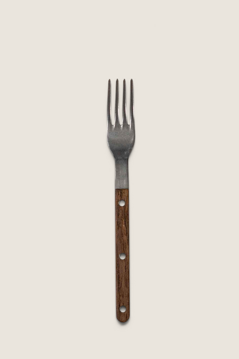 Bolina Sabre Paris Bistrot gaffel i teak med vintage design og synlige nagler på en lys tekstilbakgrunn
