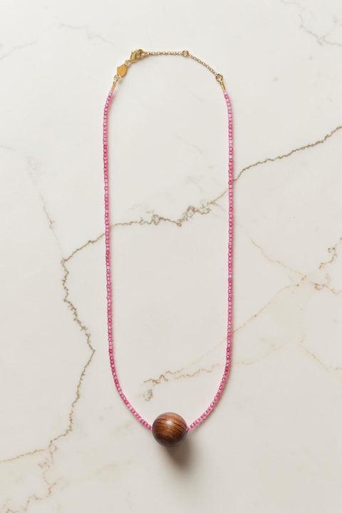Bolina ANNI LU Pink Mood necklace featuring small pink glass beads and a large sandalwood sphere with gold details.