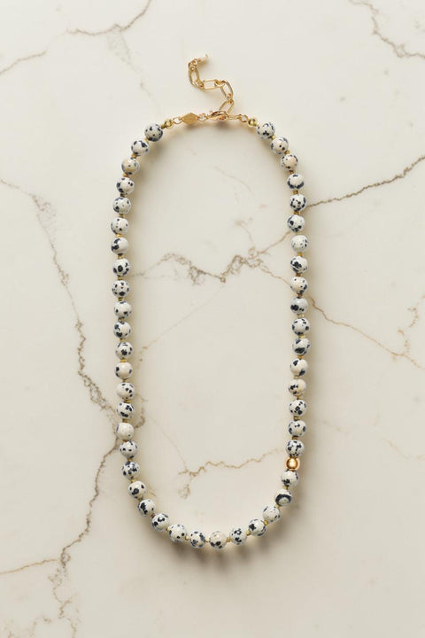 Bolina ANNI LU Pops necklace featuring round dalmatian stone beads with cream, black, and gold-tone metal accents.