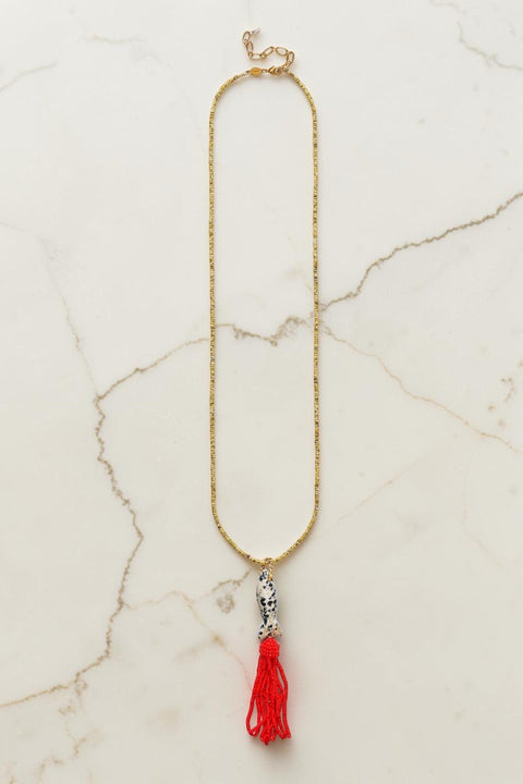 Bolina ANNI LU Tassel Fishy necklace with dalmatian stone fish pendant, gold beads, and a vibrant red beaded tassel.