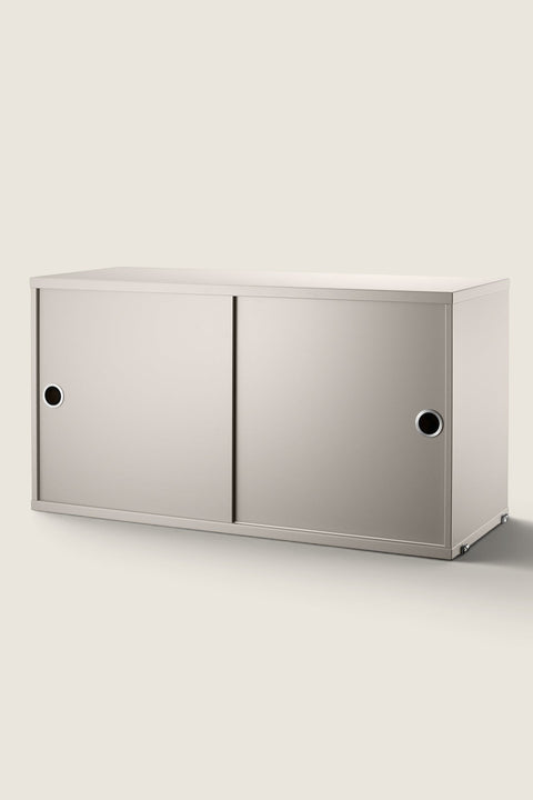Bolina beige String System cabinet with sliding doors and circular metal handles for modular wall shelving storage