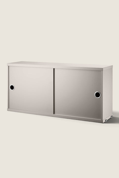 Bolina beige String System cabinet with sliding doors and circular handles for modular wall shelving storage