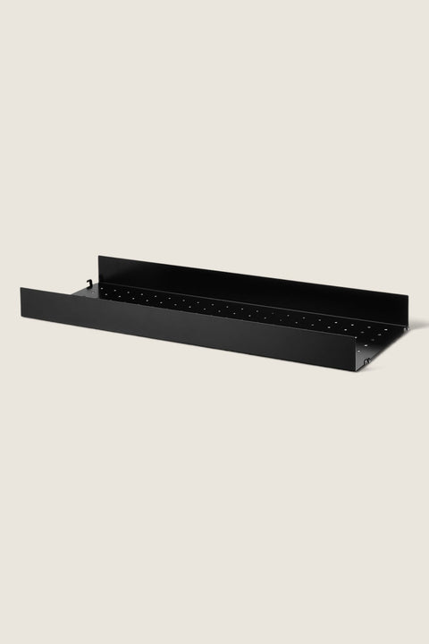 Bolina black powder-coated steel shelf with high edges and perforated surface for String System shelving