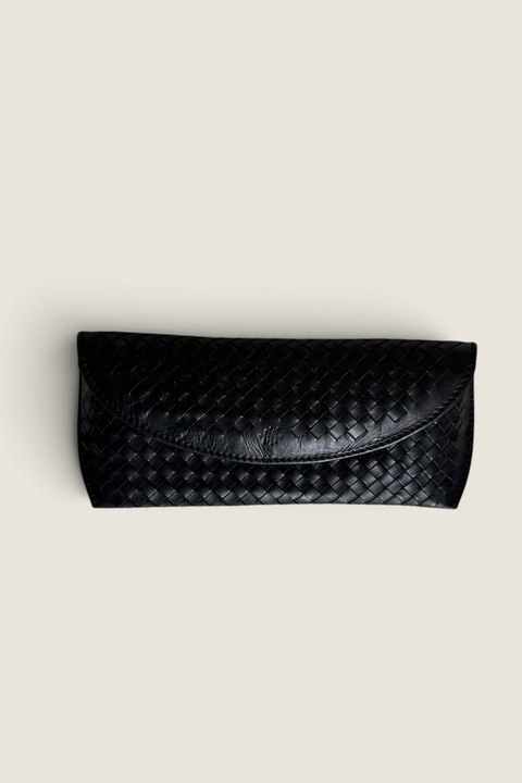 Bolina black woven leather glasses case with a flap closure and artisanal braided texture.