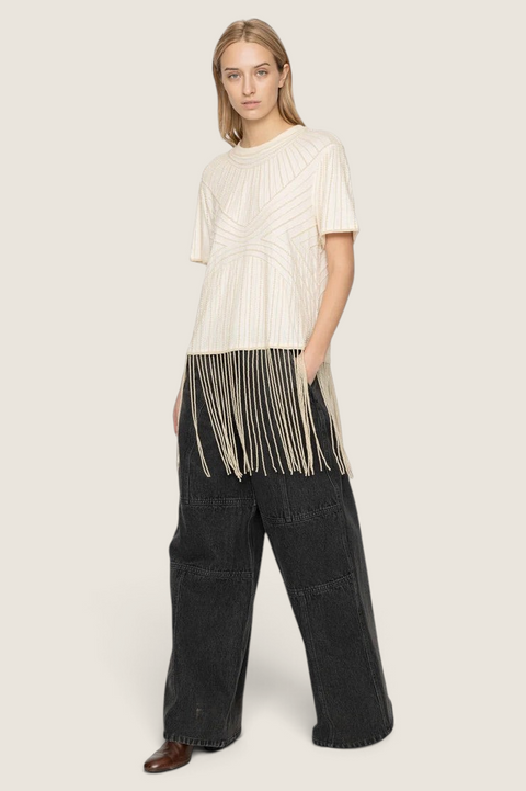 Bolina cream cotton Carlotta top with hand-beaded graphic patterns and long fringe hem worn by a model