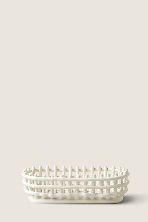 Bolina off-white ceramic basket with a woven design, perfect for bread or fruit storage on a dining table.