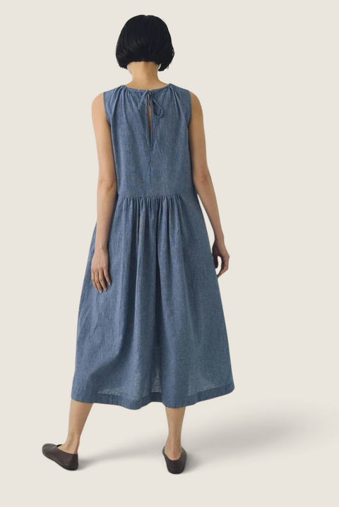 Bolina chambray blue cotton linen midi dress with a relaxed silhouette, back tie detail, and gathered waist.