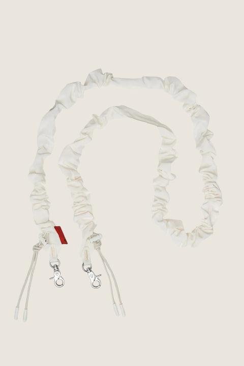 Bolina Stropp - Wares Straps Bungee Ecru Tech Sateen, a cream-colored, ruched bungee strap with silver clasps and adjustable cords.