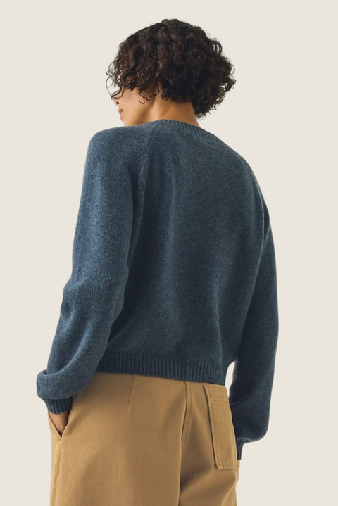Bolina Eden raglan cardigan in stormy blue merino wool and cashmere blend, shown from the back on a model.
