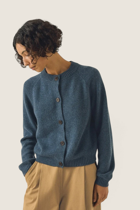 Bolina Eden raglan cardigan in stormy blue merino wool and cashmere blend with corozo buttons worn by a model.
