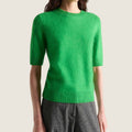Model wearing a bright green Bolina fluffy short-sleeved knit pullover with a ribbed crew neck and hem.