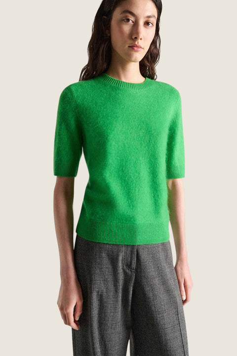 Model wearing a bright green Bolina fluffy short-sleeved knit pullover with a ribbed crew neck and hem.