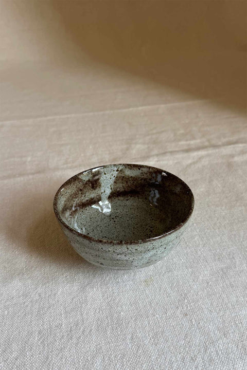 Bolina small handmade Japanese ceramic bowl in brown and speckled grey for dips or snacks on a linen surface.