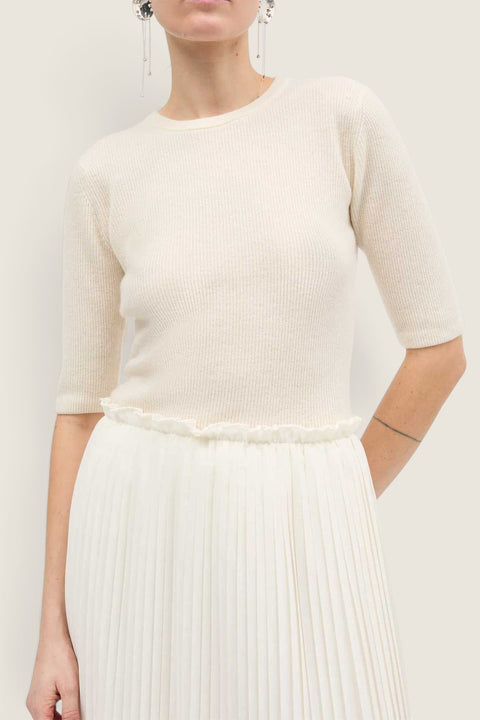 Bolina Kami short-sleeved ivory cashmere knit top with a round neck and slim fit worn with a pleated skirt