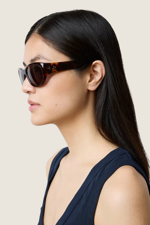 Bolina LIÉ STUDIO The Lee oversized round sunglasses in dark tortoise shell worn by a woman in profile view.