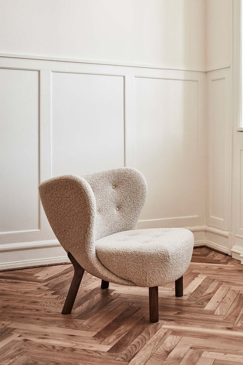 Bolina Little Petra lounge chair in cream Karakorum wool fabric with dark walnut wood legs in a bright room