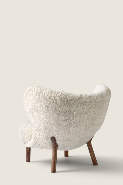 Bolina Little Petra lounge chair in cream sheepskin with dark walnut wood legs, viewed from the back