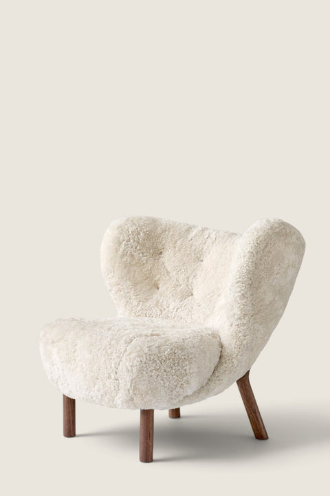 Bolina Little Petra lounge chair in cream sheepskin upholstery with dark walnut wood legs, Danish design classic.