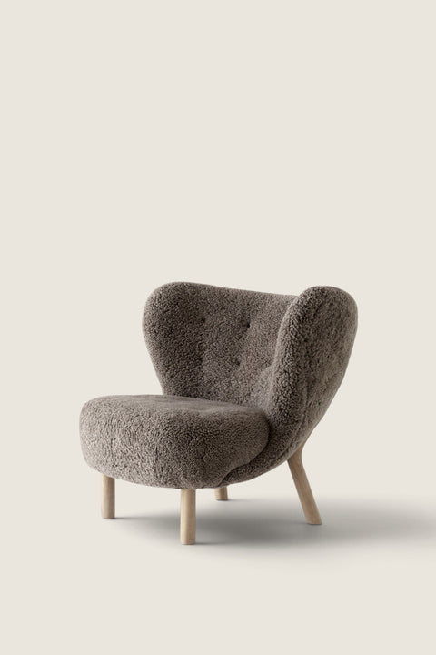 Bolina Little Petra lounge chair in dark Sahara sheepskin with light oak legs, a classic Danish design piece.