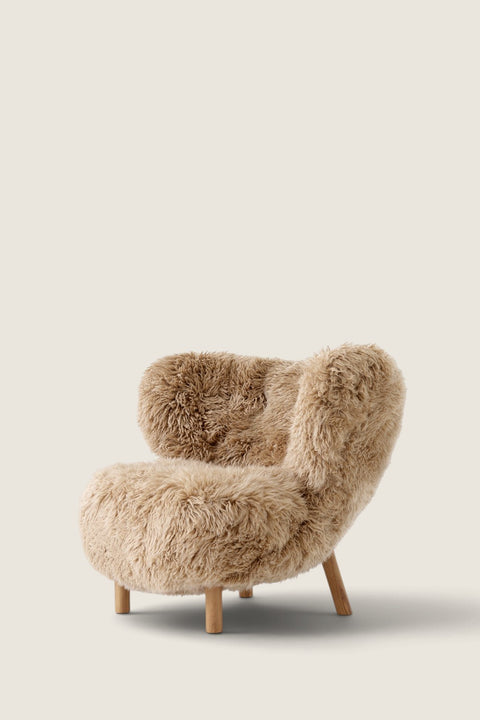 Bolina Little Petra lounge chair in honey-colored long-haired sheepskin with oiled oak legs, side view.