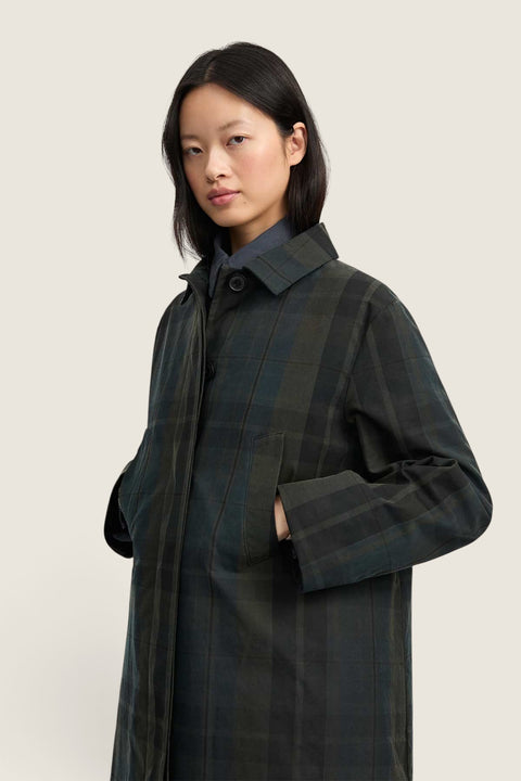 Bolina Noor coat in dark green and black plaid with a waxed finish, small collar, and hidden button closure.