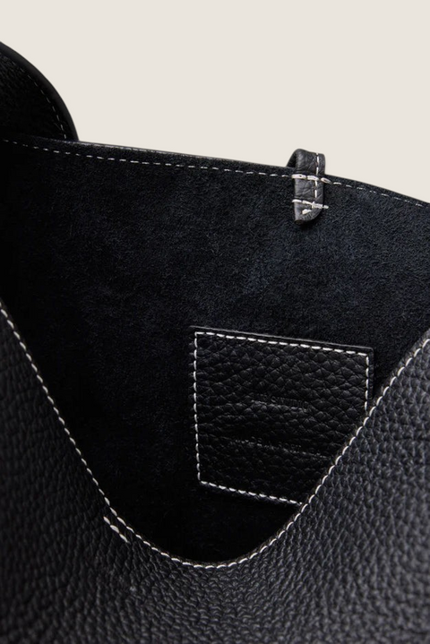 Bolina Norma Tote interior view showing black textured leather, white contrast stitching, and a branded leather patch.