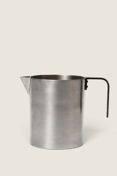 Bolina Obra milk jug in brushed stainless steel with a black textured handle and brass rivet details.