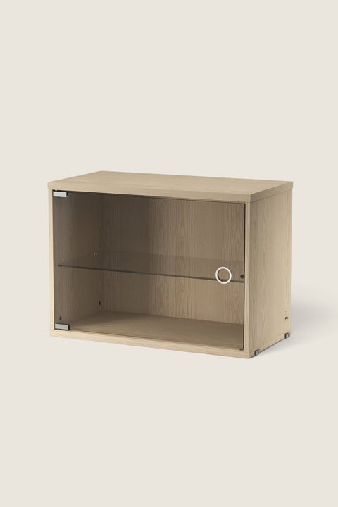 Bolina String display cabinet in ash wood with a hinged glass door and internal shelf for modular shelving systems.