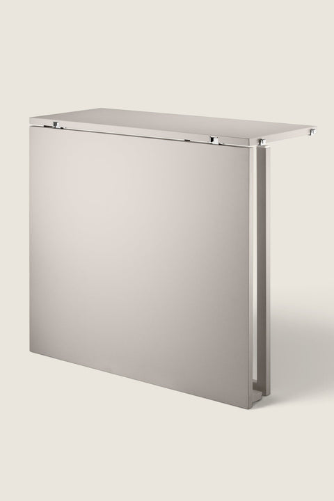 Bolina String System beige powder-coated steel folding table in a folded position for space-saving storage.