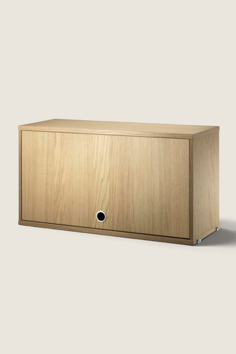 Bolina String System flip door cabinet in oak veneer with a minimalist design and circular handle
