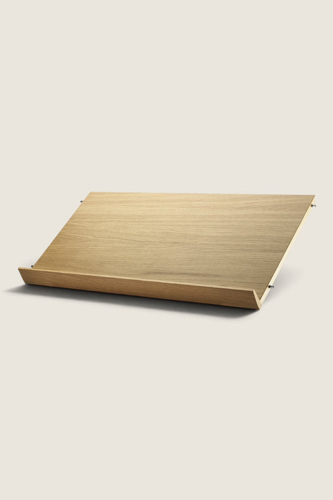Bolina String System oak veneer magazine shelf for 30cm deep panels, angled display design for books and magazines.