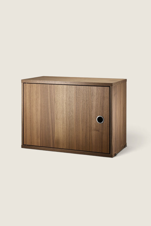 Bolina String System walnut cabinet with a single hinged door and circular handle for modular wall shelving