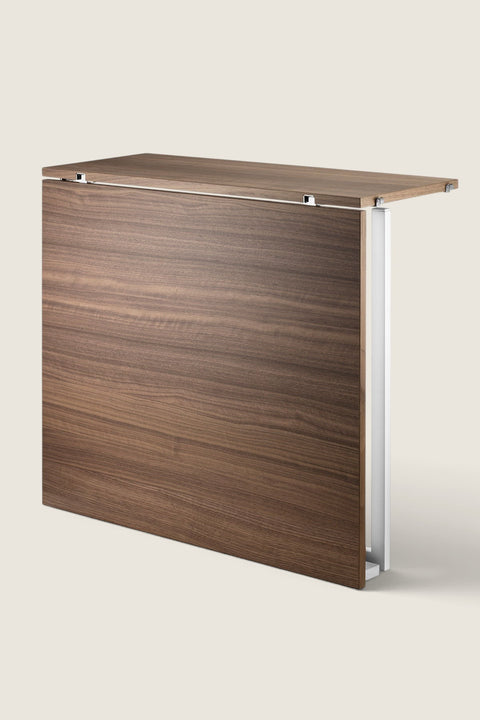 Bolina String System folding table in walnut wood finish with white frame, shown in a partially folded position.