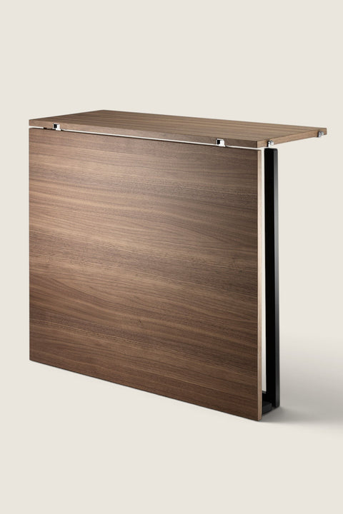 Bolina String System folding table in walnut wood with black steel frame, shown in the folded down position.