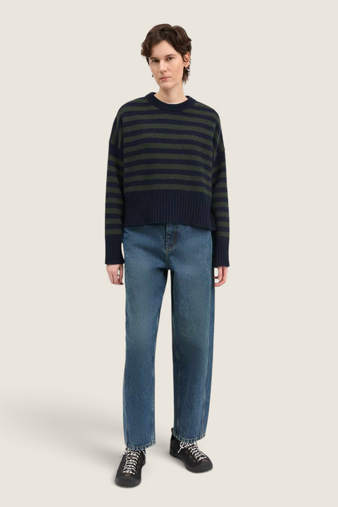 Bolina model wearing an oversized navy and dark green striped merino wool jumper with dropped shoulders and jeans