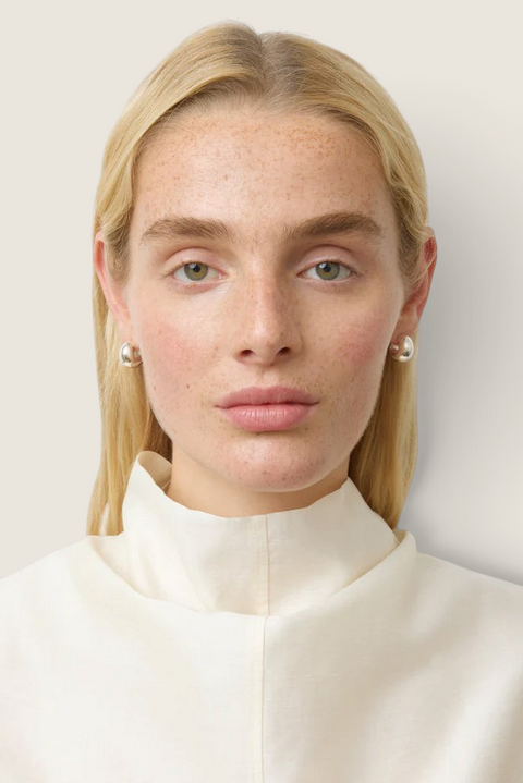 Model wearing Bolina The Simone Silver small polished round hoop earrings in a minimalist style