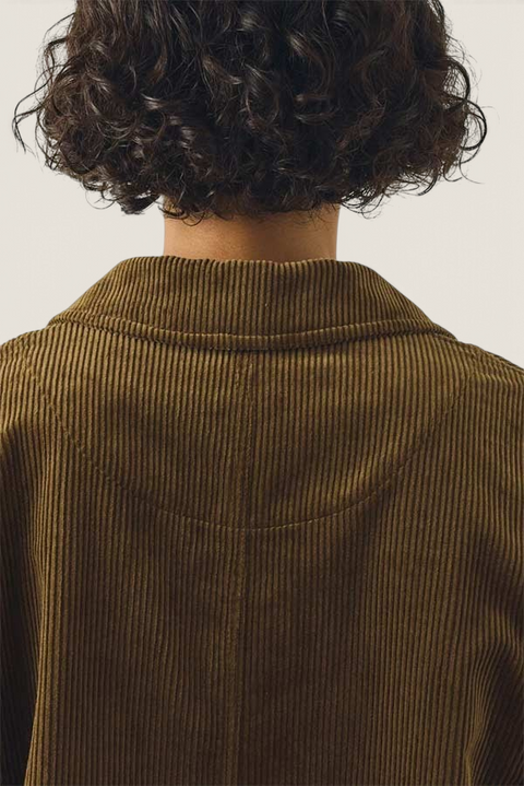 Back view of a Bolina TOAST bronze green organic cotton corduroy jacket with a rounded collar and textured finish.