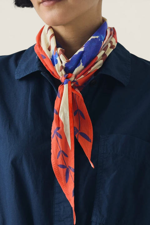 Bolina TOAST cotton bandana in cobalt blue and orange with a painterly folk-art flower crown print worn at the neck