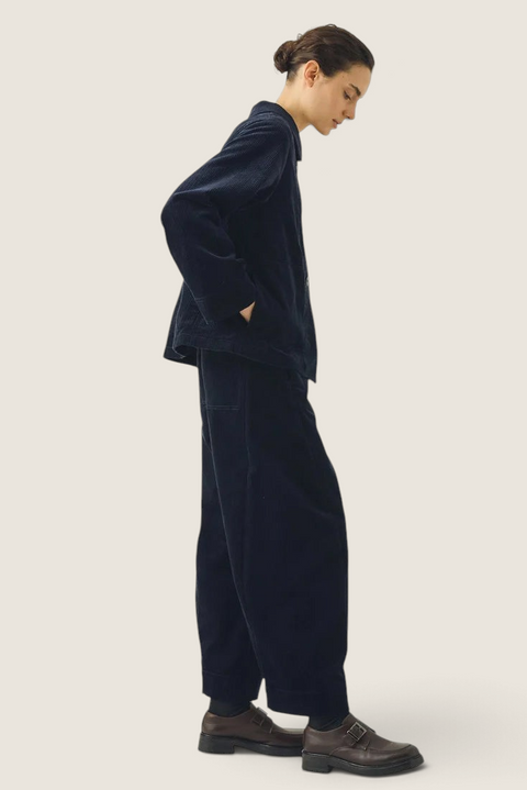 Model wearing Bolina TOAST dark navy corduroy barrel-leg trousers with twisted seams and cropped length