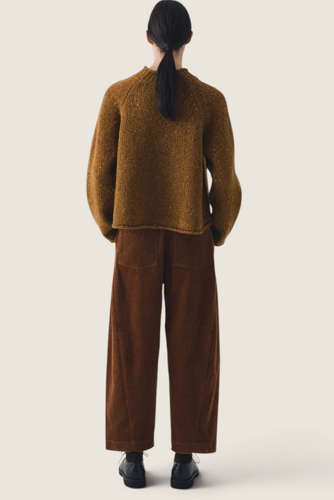 Bolina TOAST Orla Donegal wool sweater in straw yellow with raglan sleeves and rolled edges, worn with brown trousers.