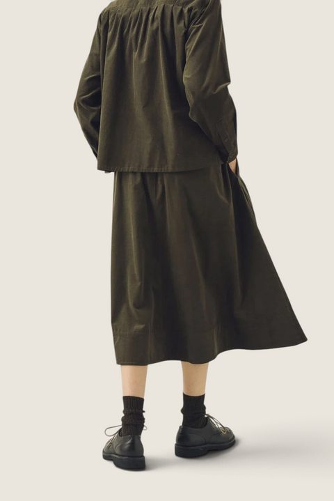 Bolina TOAST seaweed green A-line needlecord cotton skirt worn with matching shirt and dark shoes, back view