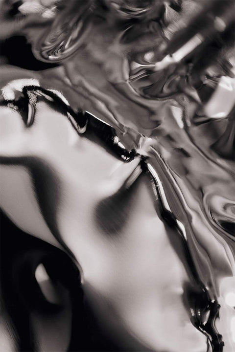 Bolina Tydra bowl in mirror polished stainless steel with a fluid, wavy design reflecting light.